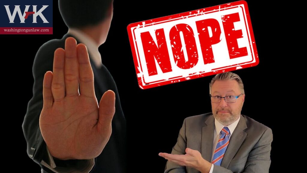 A man in a suit points to a large red "NOPE" sign with an illustration of a hand raised as if signaling to stop. The background is black and features a logo in the top left corner.