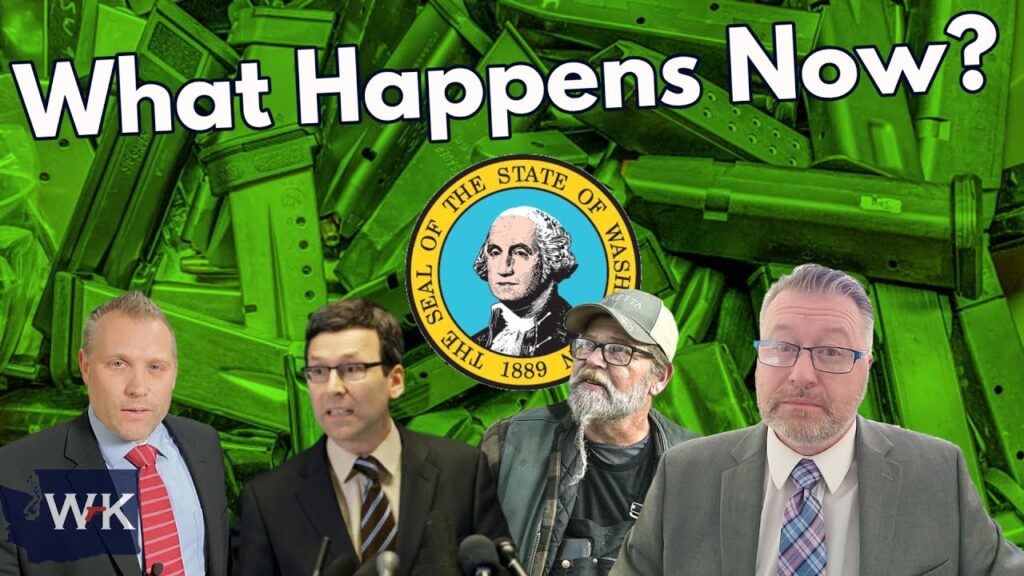 A group of four men stands against a backdrop of green ammunition magazines. Above them, bold white text reads "What Happens Now?" and the Washington State seal is prominently displayed. Each man is wearing a suit, and one is in casual clothing.