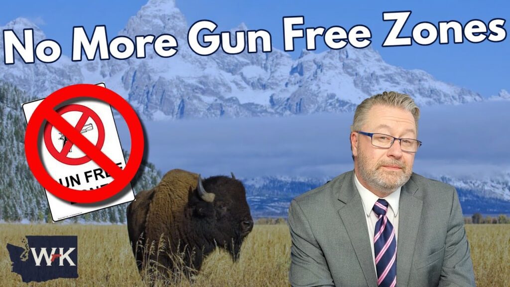 A man in a suit and tie stands in front of a backdrop featuring a bison in a field with mountains. Text reads "No More Gun Free Zones" with a crossed-out gun-free sign. A logo with "WK" is at the bottom.