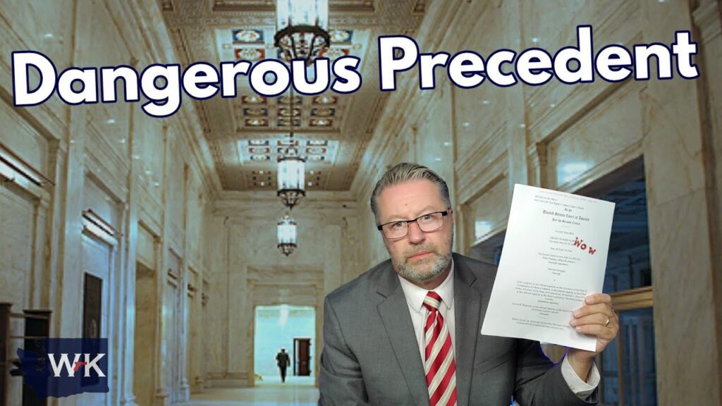 A man in a suit and striped tie holds up a document in a grand hallway with chandeliers. Large text above him reads "Dangerous Precedent." The WK logo is in the bottom left corner.